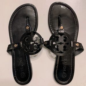 Black Tory Burch shiny sandals. Gold accents